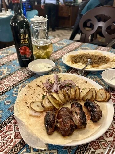 LaQuzu restoranında kabab və garnir ilə yemək təqdimatı