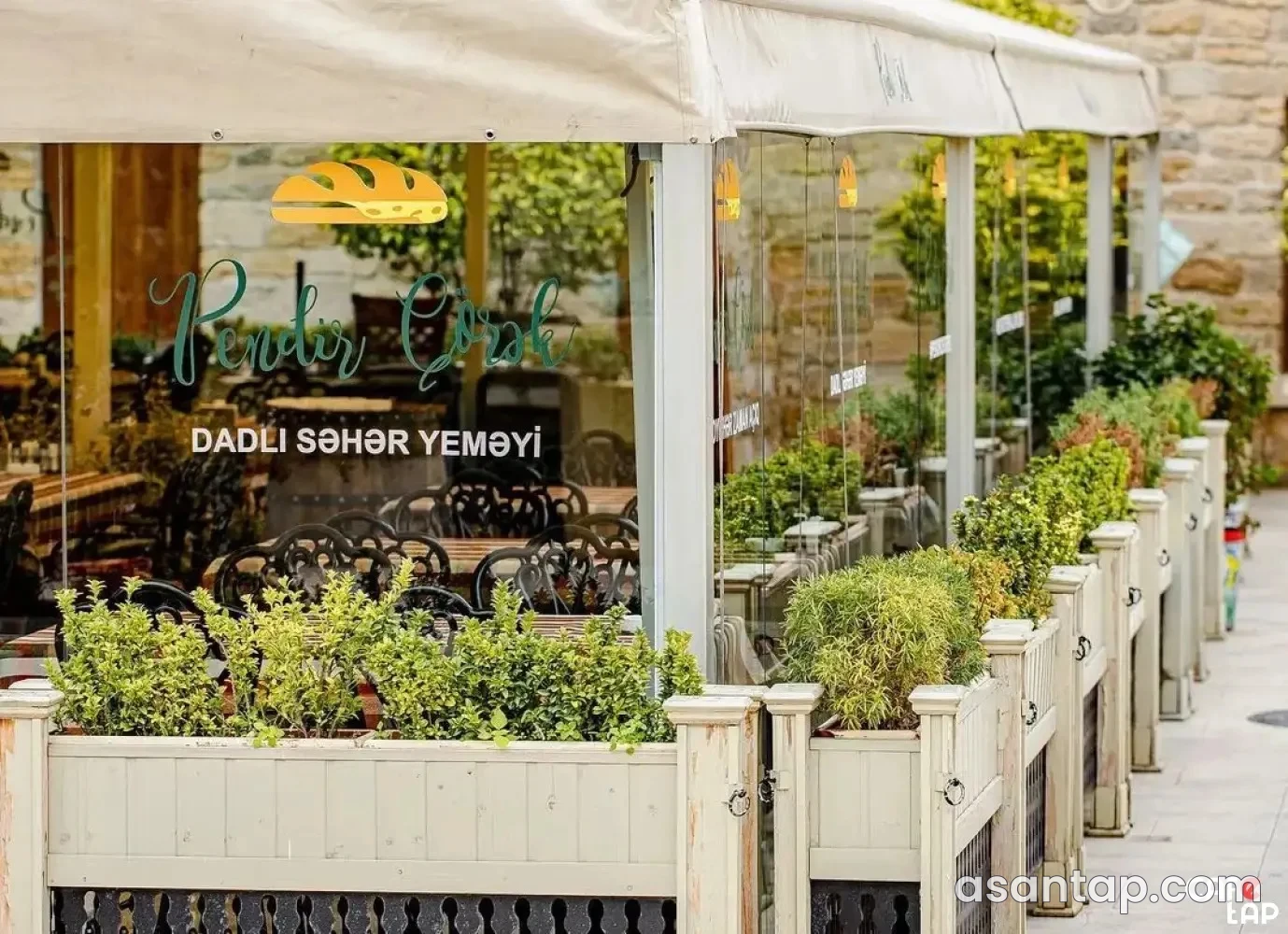 Pendir Çörək restoranının pəncərəli yemək sahəsi və açıq oturacaqları
