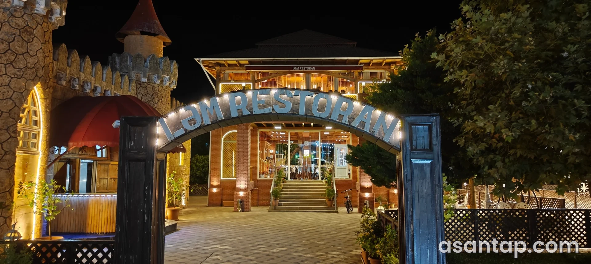 Astara bulvarındakı Ləm restoranının adı görünən işıqlı giriş qapısı və taxta eyvanı