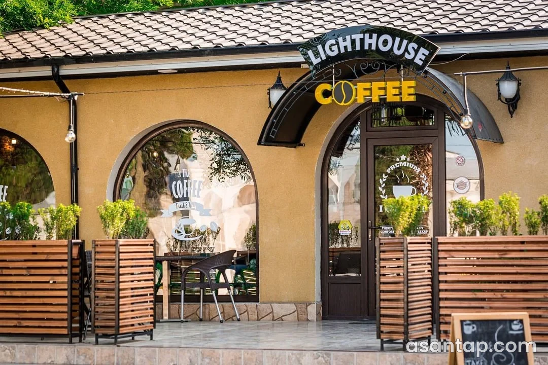 Lighthouse Coffee-nin adlı giriş lövhəsi və tağlı fasadı