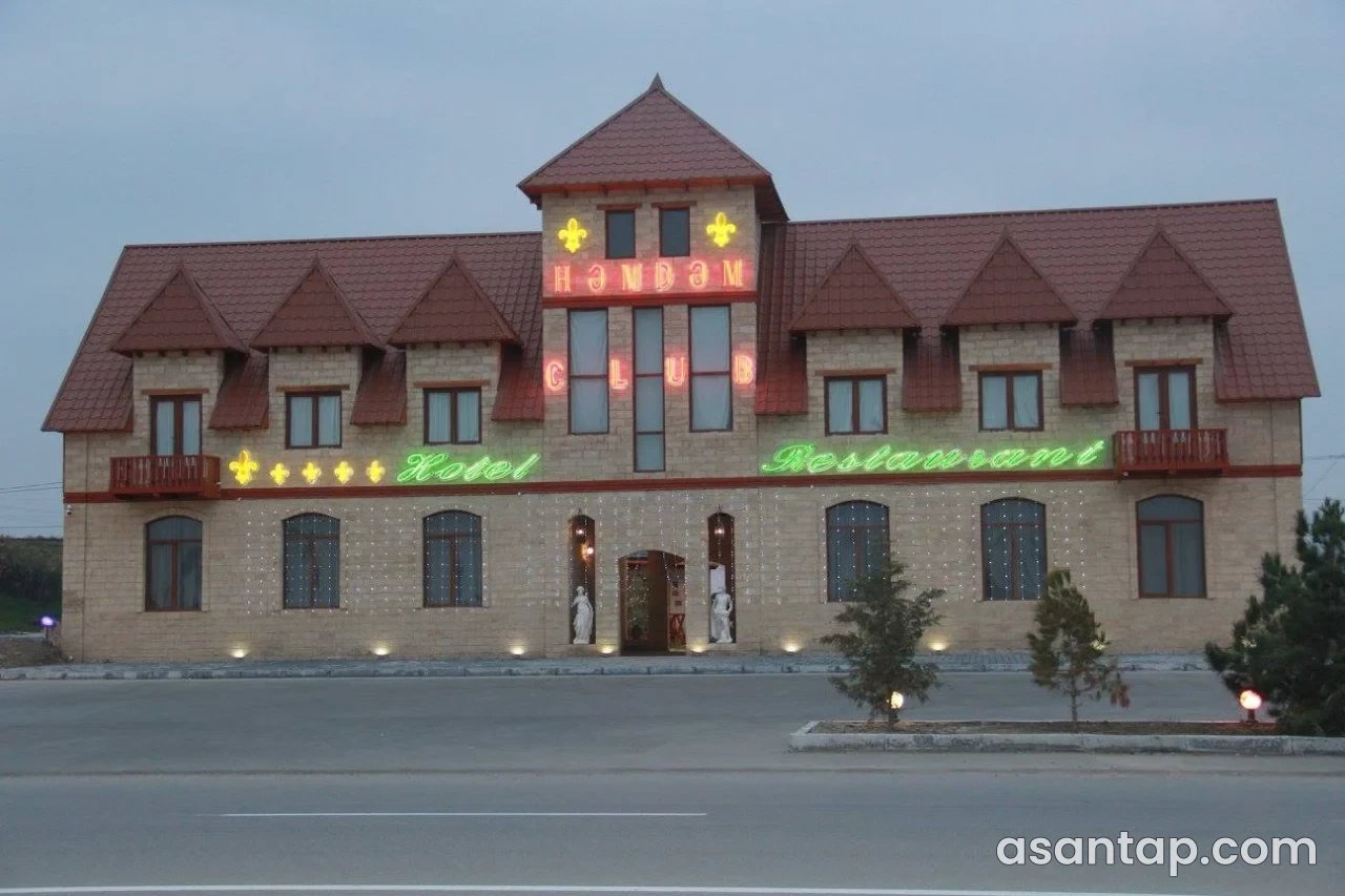 Həmdəm restoranının adı işıqlandırılmış qırmızı damlı fasadı və əsas girişi