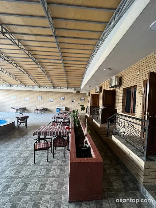 Qədiroğlu Sahil Restoranın örtülü həyətində masalar və oturma sahəsi