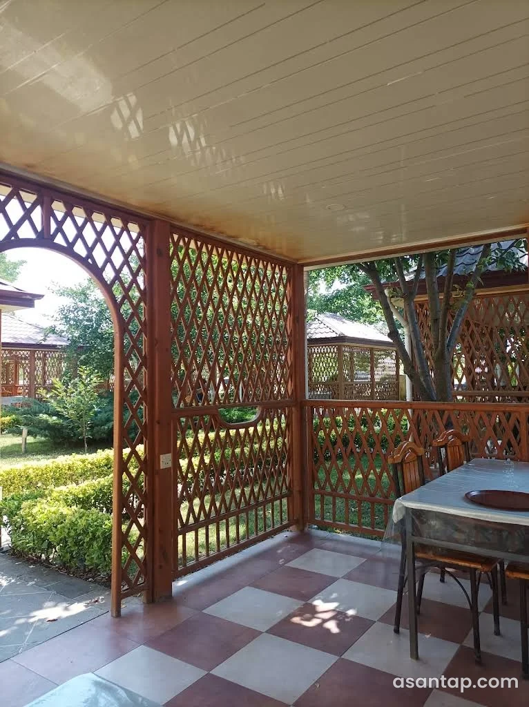 Yurd restoranında taxta qəfəsli bağ köşkü və masa