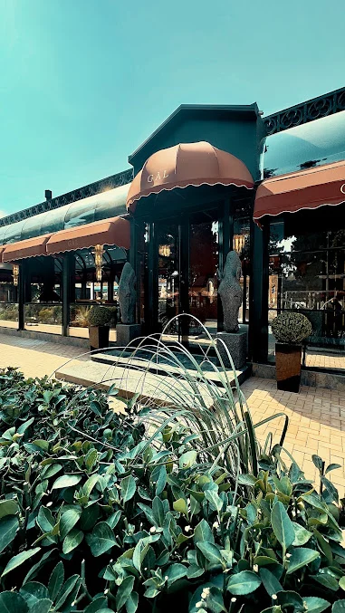GÀL restoranının narıncı tentli, at fiqurları və yaşıl bitkilərlə bəzədilmiş girişi