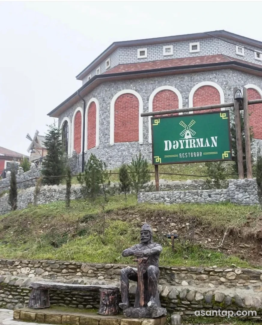 Dəyirman Restoranının adlı yaşıl lövhəsi, dəyirman motivi və tağlı daş binası