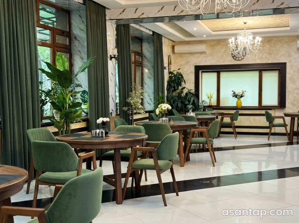 Green Park restoranının yaşıl oturacaqlı və dairəvi masalı qapalı zalı