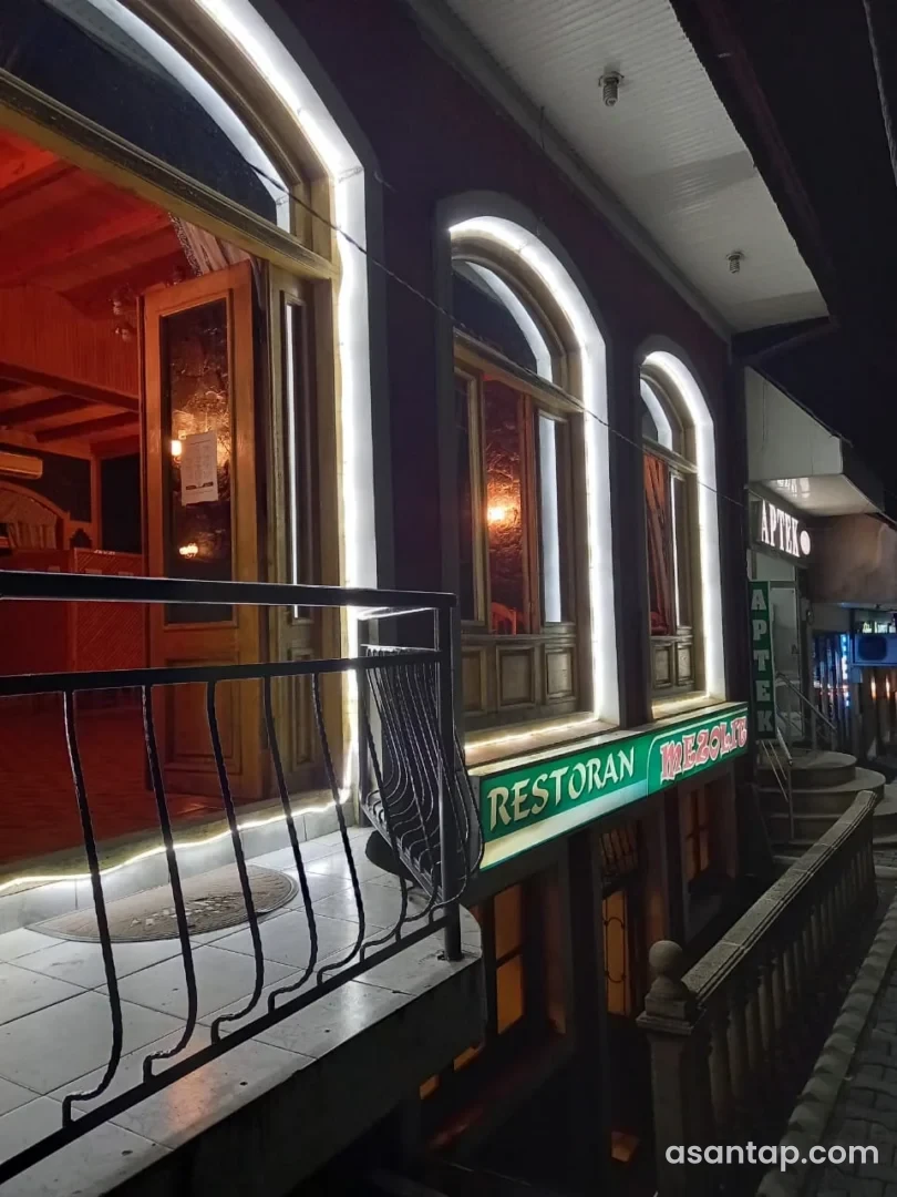 Qaxdakı Mezolit restoranının işıqlı fasadı və MEZOLIT RESTORAN lövhəsi