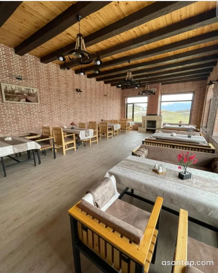 Yarpızlı restoranının kərpic divarlı zalı, taxta tavanı və masaları