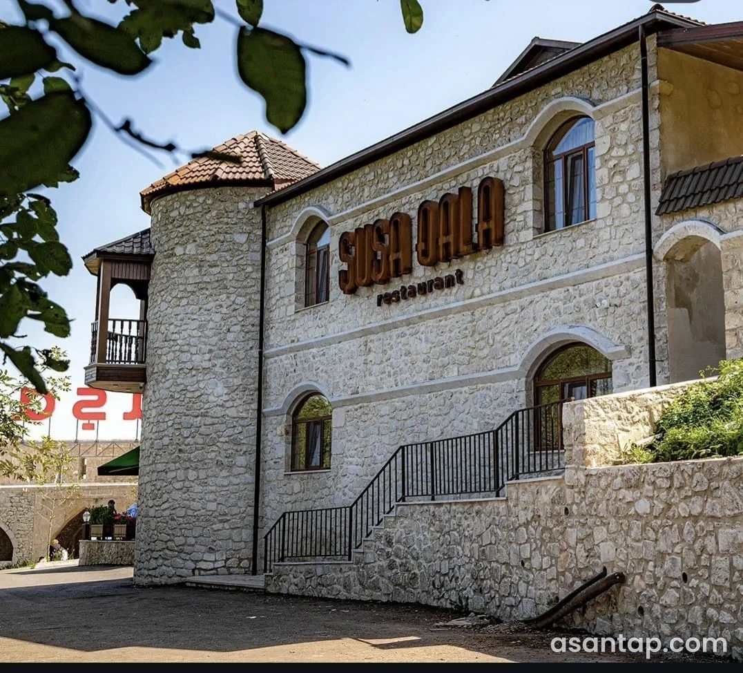 Şuşa Qala restoranının ad lövhəli daş fasadı, tağlı pəncərələri və giriş pilləkəni
