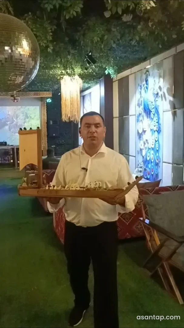 Qədim Şəmkir restoranında əməkdaşın qayıq formalı qabda yemək təqdimatı və tovuzquşu təsvirli zal