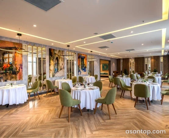 Ahəng Restoran Şabranda yaşıl oturacaqlı və ağ örtüklü masaları olan zal