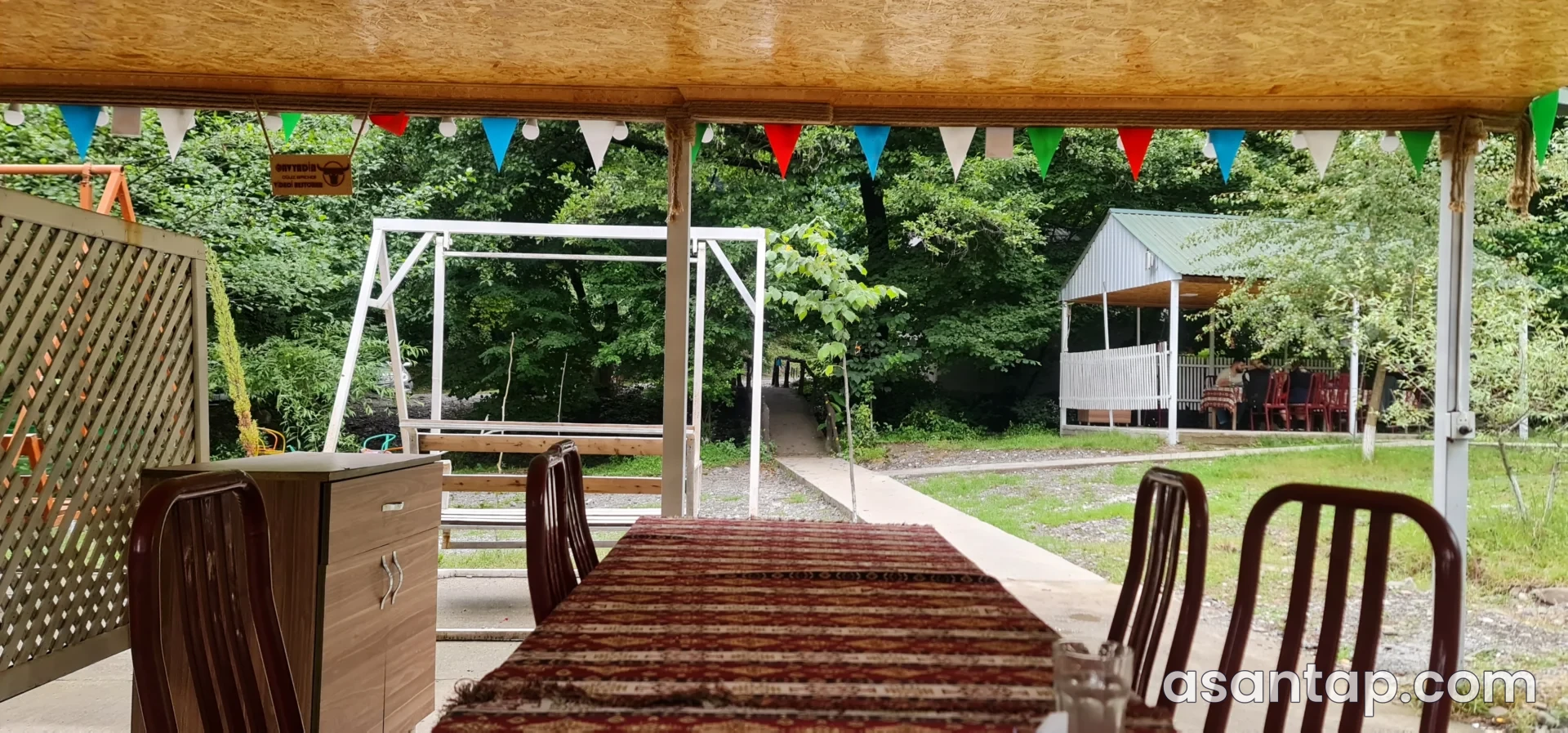Vidadi restoranının ağaclıq həyətə baxan üstüörtülü masaları və söhbətgahı