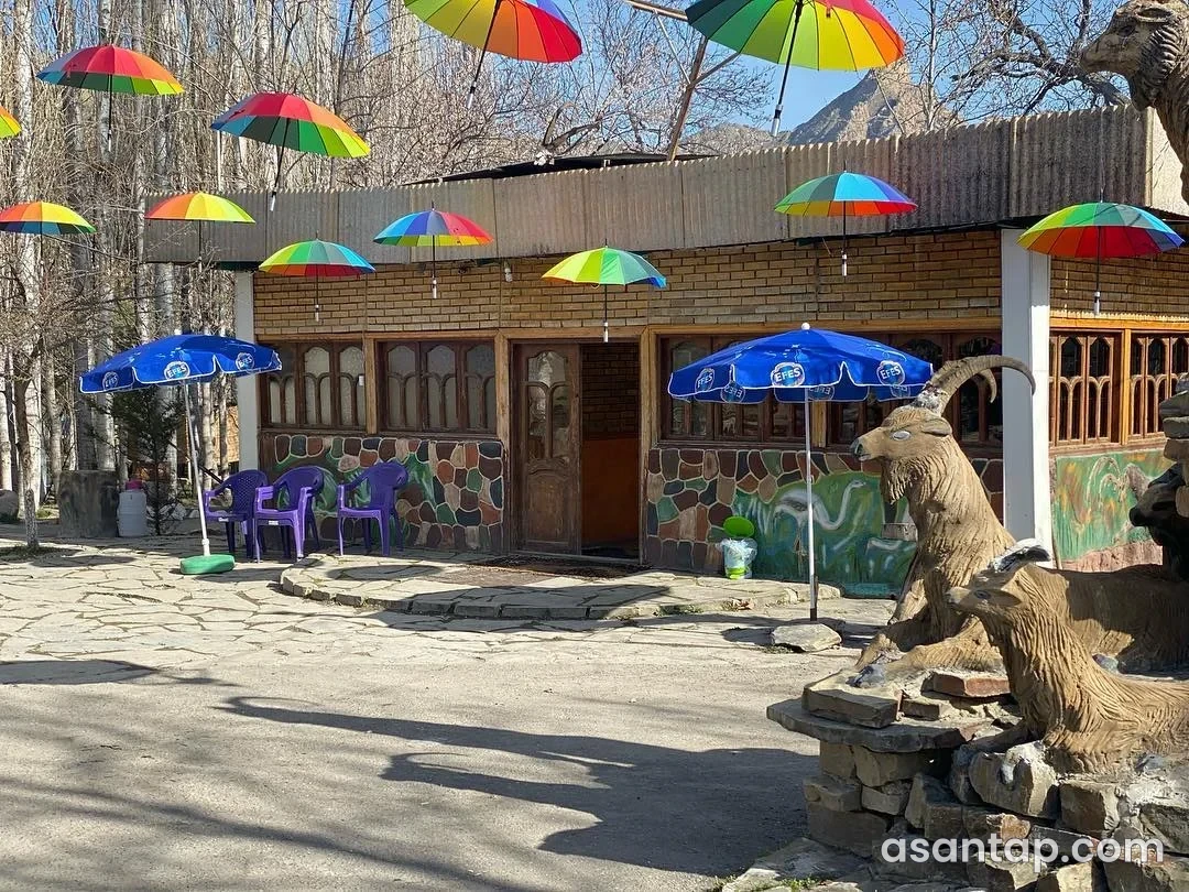 Şora Çeşmə restoranının rəngli çətirli həyəti, ağac çərçivəli pəncərələri və dağ keçisi dekorları