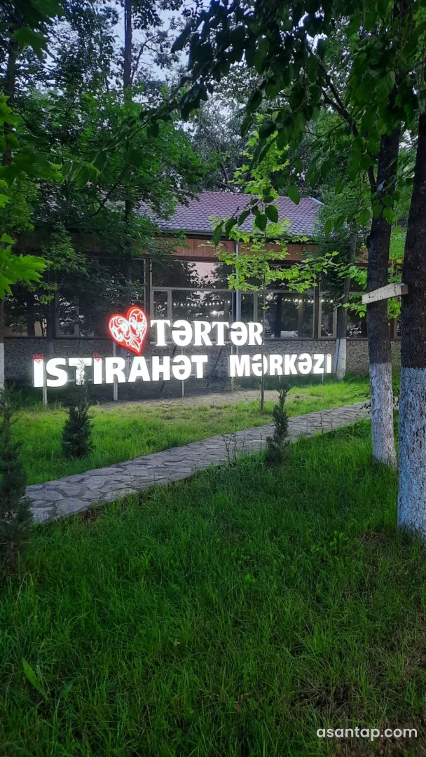 Tərtər İstirahət Mərkəzinin işıqlı ad lövhəsi, ağaclı həyəti və arxadakı restoran binası
