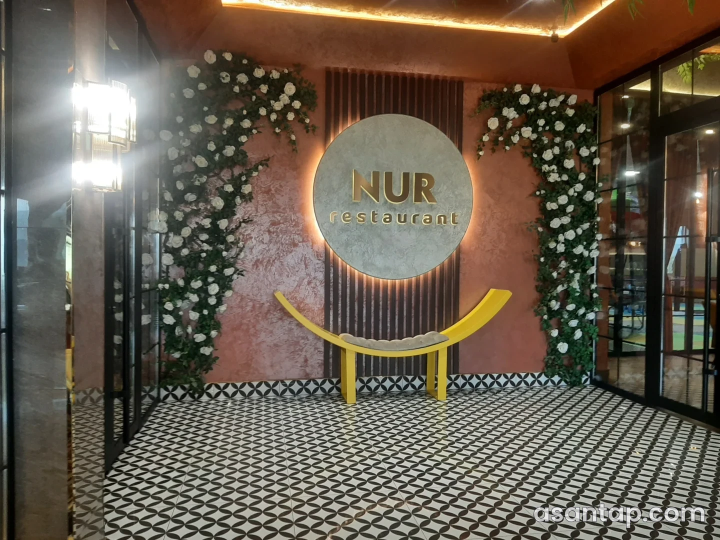 Gədəbəy Nur restoranının girişində NUR restaurant yazılı dairəvi dekor və güllü divar — 23 may 2026