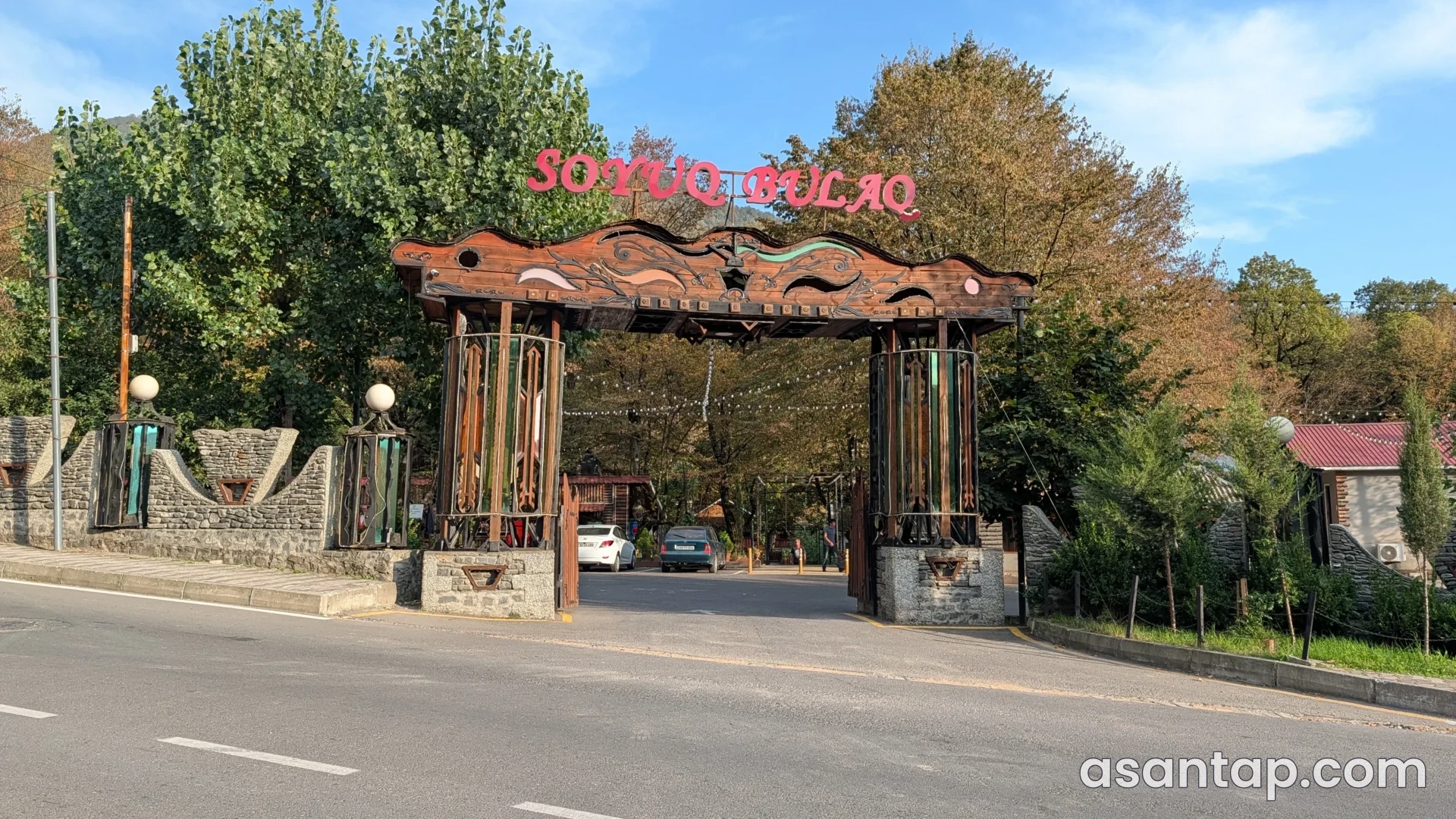Soyuq Bulaq Qəbələ restoranının ağaclarla əhatələnmiş taxta və daş giriş qapısı