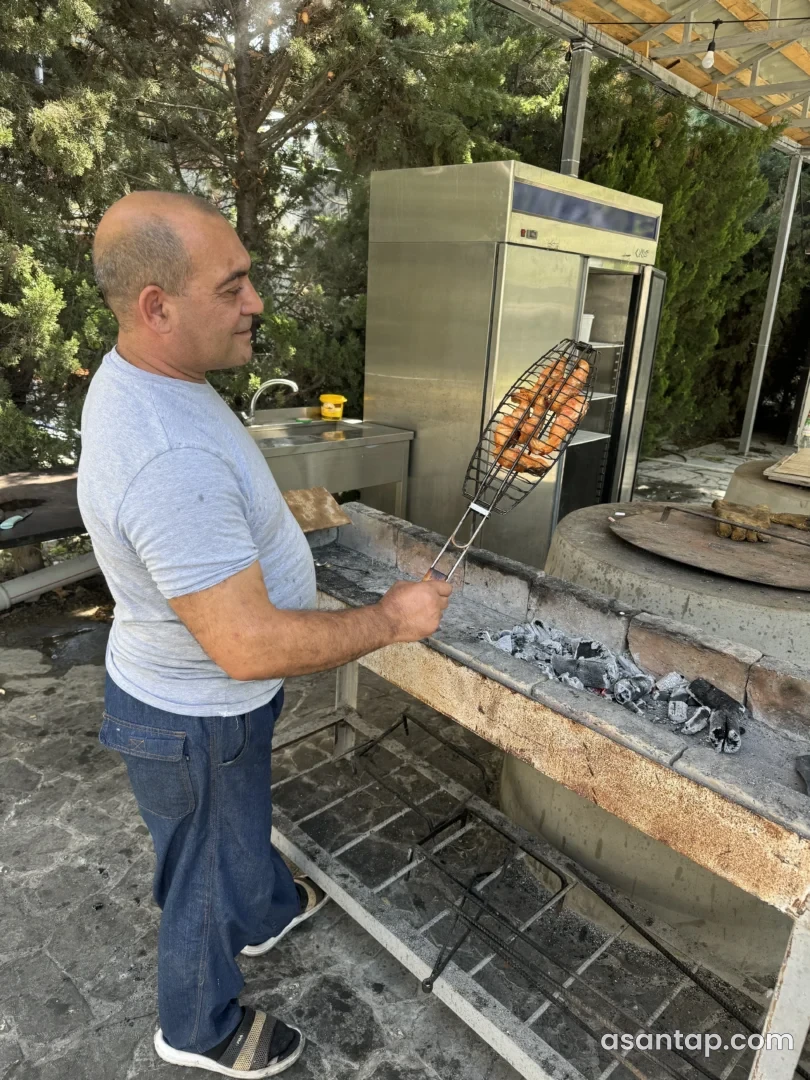 Ish Fish restoranının açıq hazırlıq sahəsində balığın manqal üzərində bişirilməsi