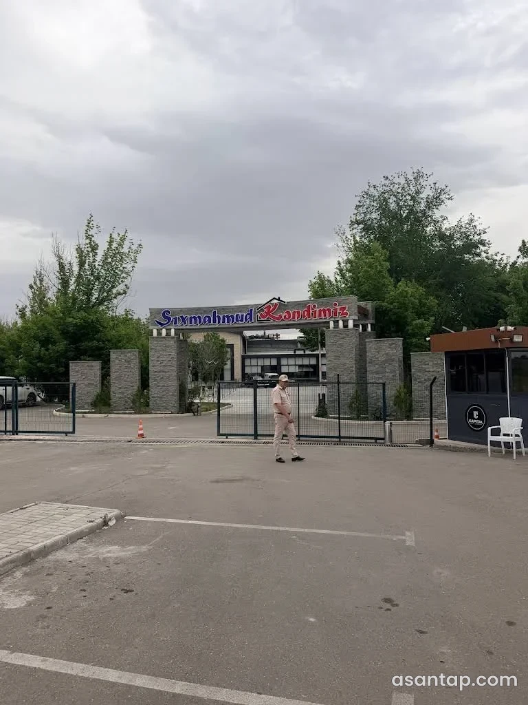 Kəndimiz Şıxmahmud restoranının lövhəli giriş qapısı, daş sütunları və arxadakı şüşəli bina