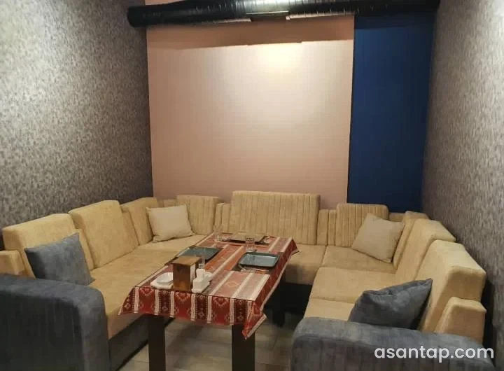 Tala Rooms restoranının naxışlı süfrə örtüyü, divanlar və kreslolarla qurulmuş ayrıca yemək otağı