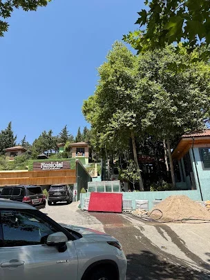 Restotal restoranının yazılı girişi, pilləkənlər və ağaclı yamacda ayrı damlı tikililər