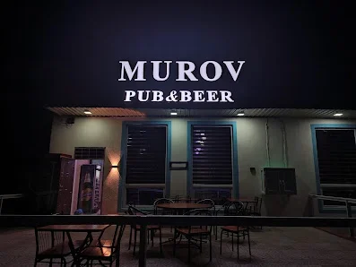 MUROV PUB&BEER yazısı, göy pəncərələri və açıq masaları görünən pab fasadı.