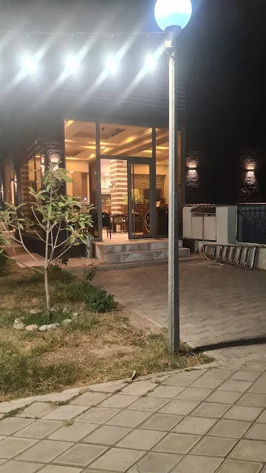 Cafe Park restoranının şüşəli girişi, pillələri, həyət yolu və işıqları