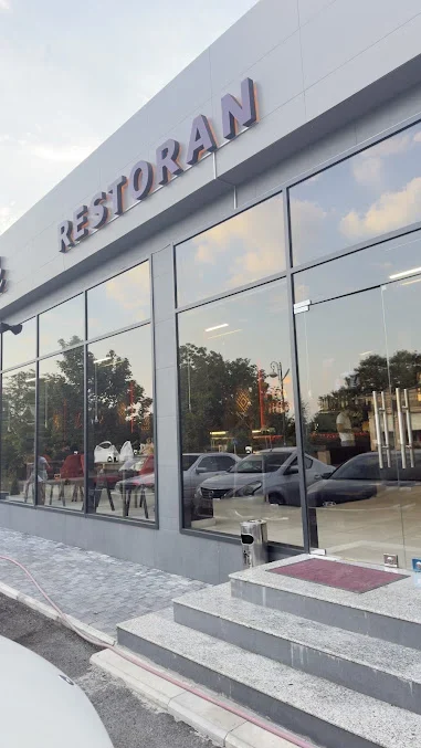Dadlı Qəbələ restoranının şüşəli fasadı, giriş pillələri və içəridə görünən işıqlı naxışlar