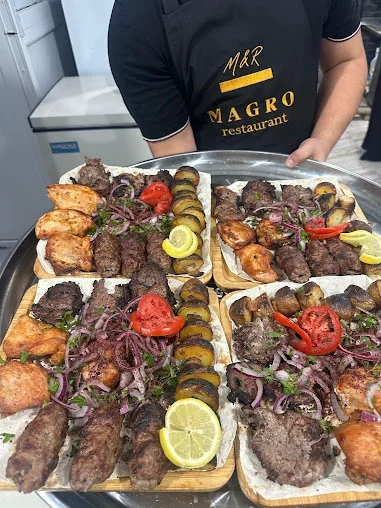 MAGRO yazılı önlük geyinmiş əməkdaşın təqdim etdiyi kabab süfrələri