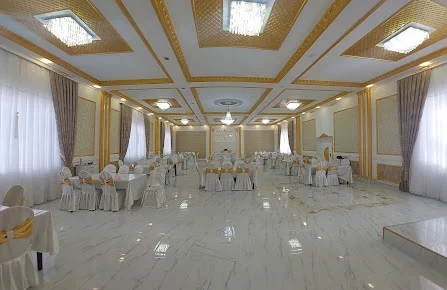 Fəvvarələr ailəvi restoranının ağ-qızılı bəzəkli, dairəvi masalı salonu