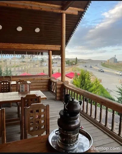 Villa Garden Qobustanın örtülü taxta terrasında çay süfrəsi və yol mənzərəsi