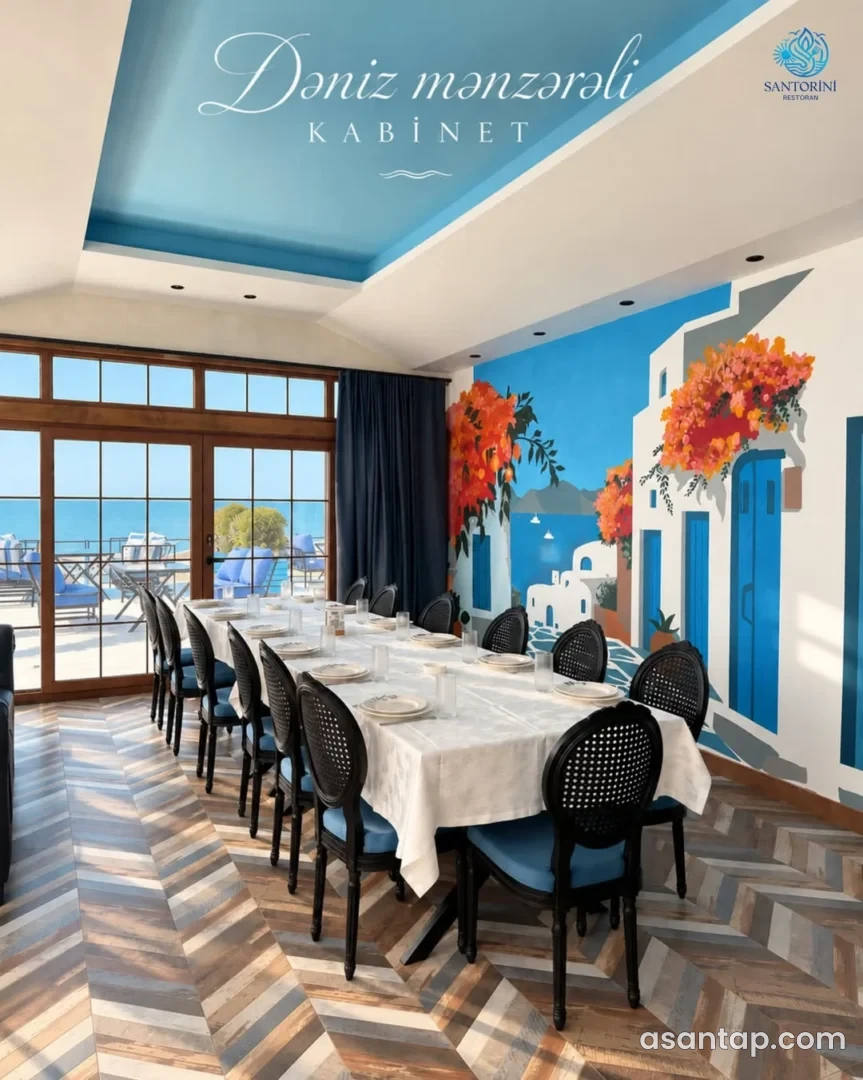 Santorini restoranında mavi-ağ divar rəsmi, uzun masa və dənizə açılan kabinet