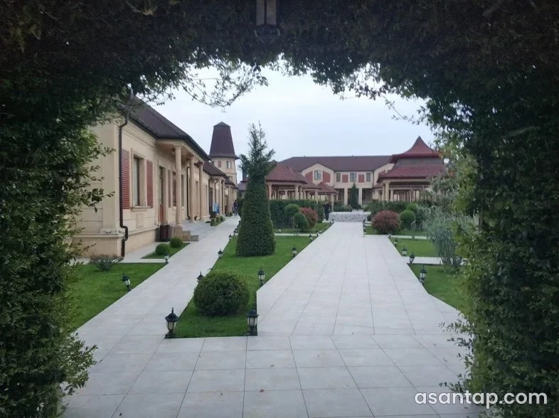 Çeşmə restoranının sütunlu tikililər arasındakı yaşıllıqlı həyəti