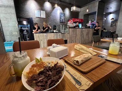 Alove restoranında yemək masası, taxta səthli piştaxta və boz divarlı salon