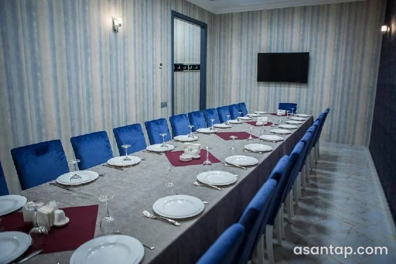 Rate restoranında uzun süfrə, göy stullar və zolaqlı divar örtüyü