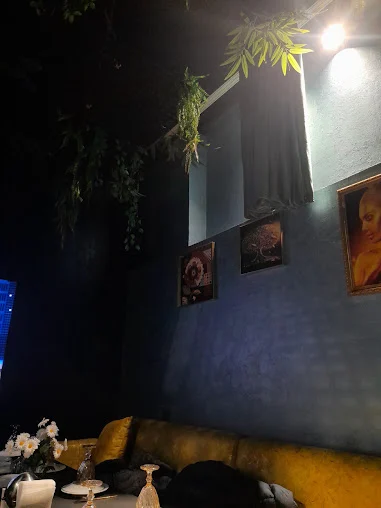 Aristokrat restoranının mavi divarlı, tablolu və yumşaq oturacaqlı salonu