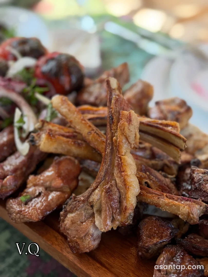 Villa Qala restoranının V.Q nişanlı lövhəsində kabab, soğan və bişmiş tərəvəzlər