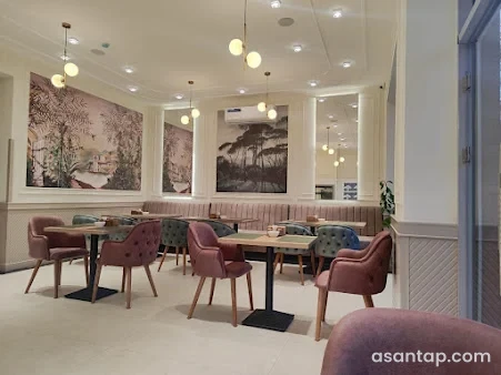 Alove Astara restoranında mənzərə rəsmləri, asma işıqlar və pastel rəngli oturacaqlar