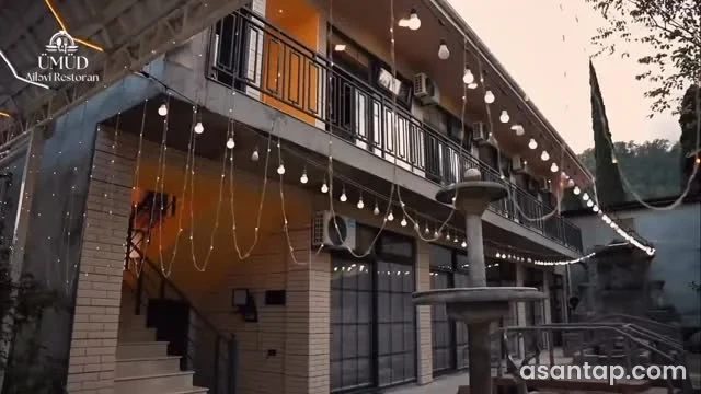 Ümüd restoranının ikimərtəbəli binası, həyət fəvvarəsi və asma işıqları