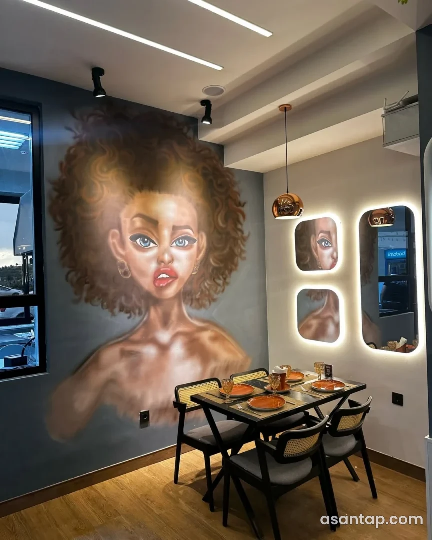 Hope restoranında iri portret rəsmi, işıqlı güzgülər və narıncı boşqablı masa