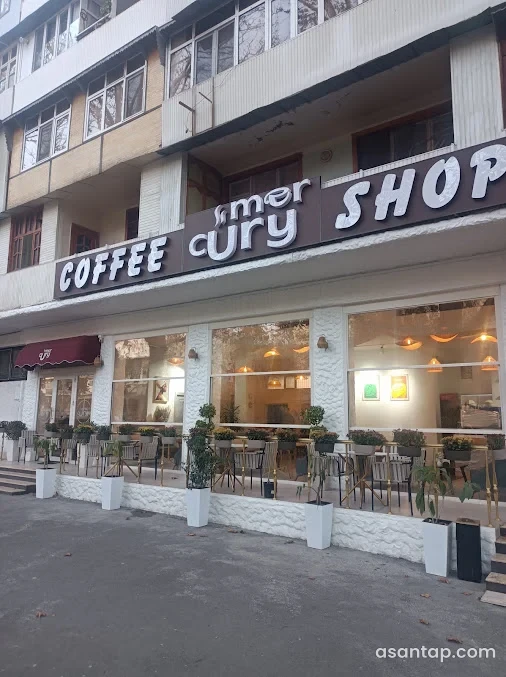 Mercury kafesinin Coffee Shop yazılı fasadı, iri pəncərələri və önündə masalı oturma sahəsi; 2025-ci il arxiv fotosu