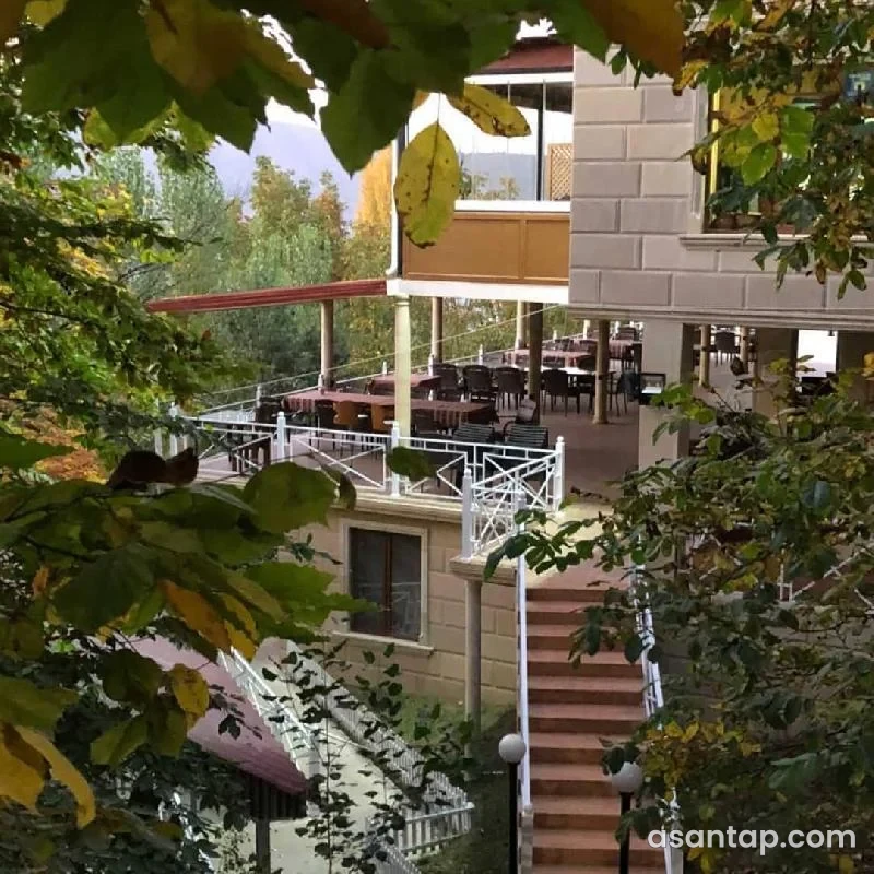 Vələs Garden restoranının ağaclar arasında örtülü terras masaları və pilləkəni