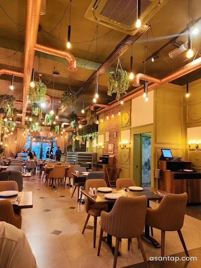 Manqal’da restoranının mis rəngli hava boruları, asma işıqlar və masa sıraları olan salonu