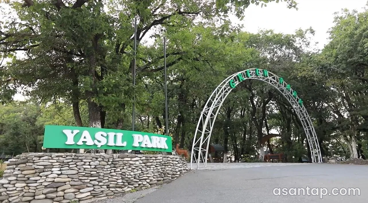 Ağsu Green Park restoranının ağaclı həyətə açılan metal tağlı və Yaşıl Park lövhəli girişi