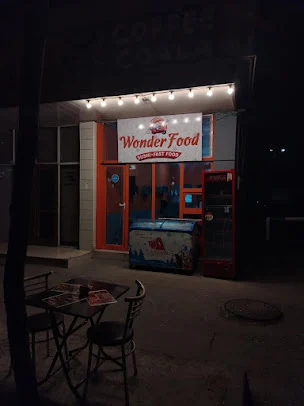 WonderFood By Fagan məkanının işıqlı lövhəsi, narıncı qapı-pəncərəsi və ön masası