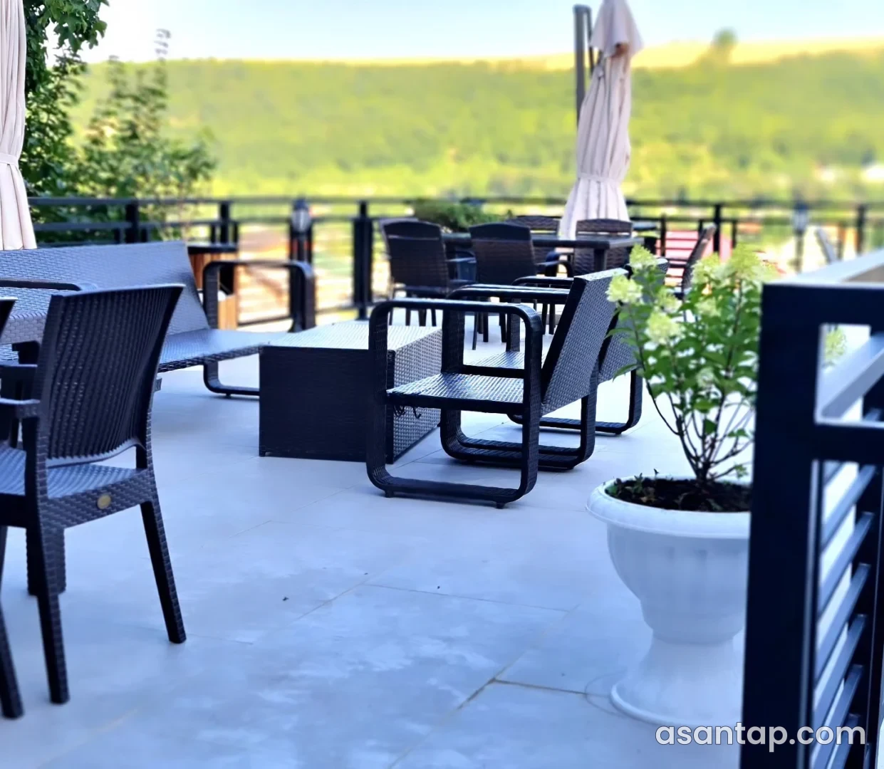 SS restoranının açıq terrasındakı hörmə kreslolar, masalar və yaşıllıq mənzərəsi
