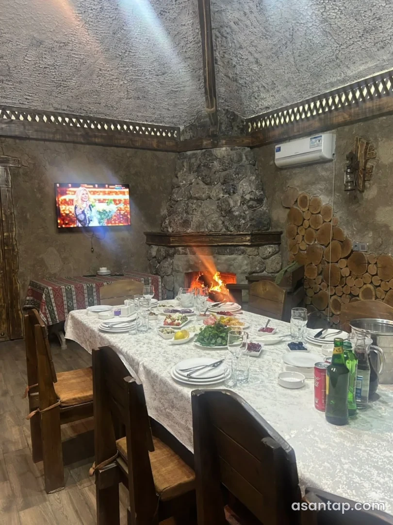 Starıy Dvor restoranında daş buxarı və qurulmuş masa olan ayrıca otaq
