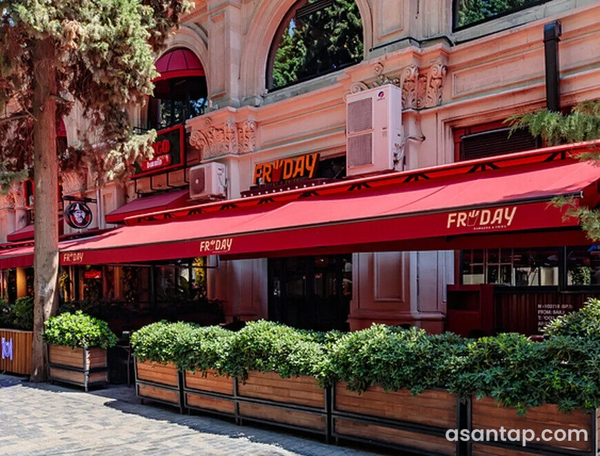 FryDay — Rəsulzadə — qırmızı tentli fasad və bitkilərlə ayrılan oturma hissəsi