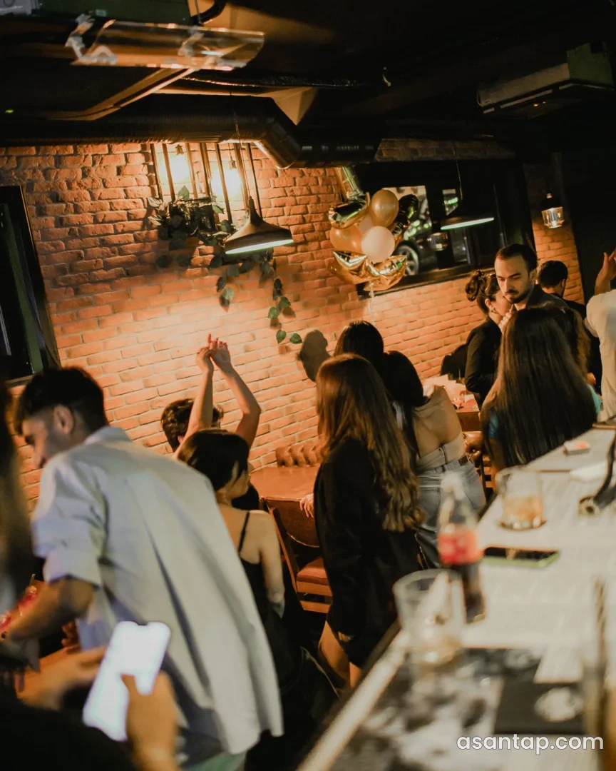Barfly Social Hub-un kərpic divarlı interyeri və bar ətrafındakı oturma sahəsi