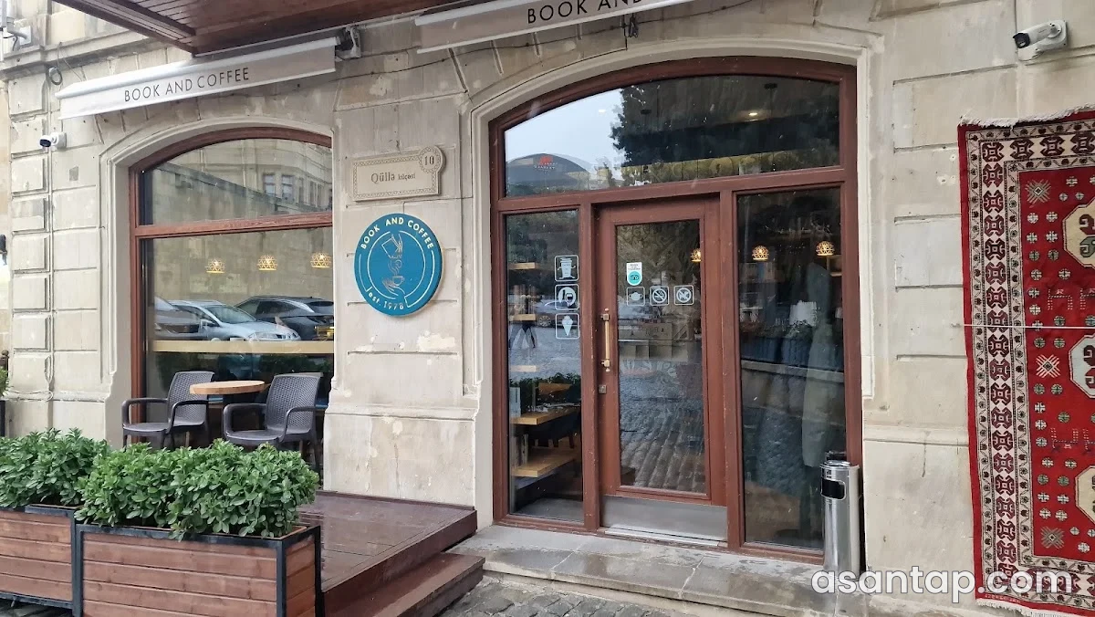 Book and Coffee-nin giriş lövhəsi və açıq oturma sahəsi