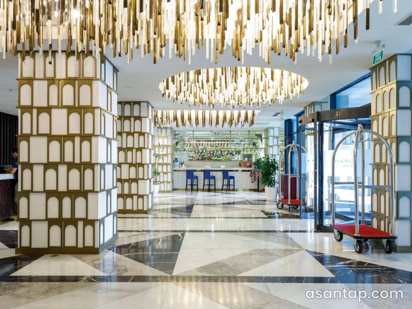 Mercure Baku City Lobby Bar — rəsmi fotoda giriş arxasında bar piştaxtası və mavi oturacaqlar